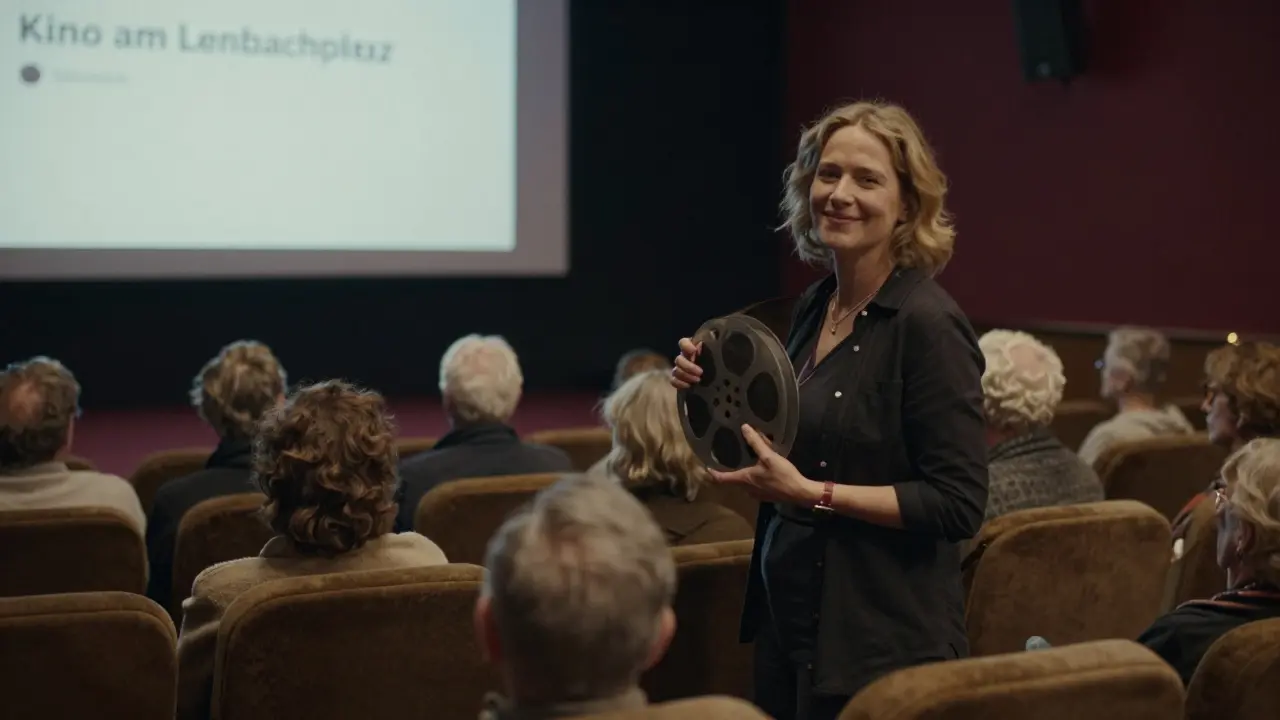 Sandra Star standing in a dim cinema, holding a film reel as an audience waits quietly.